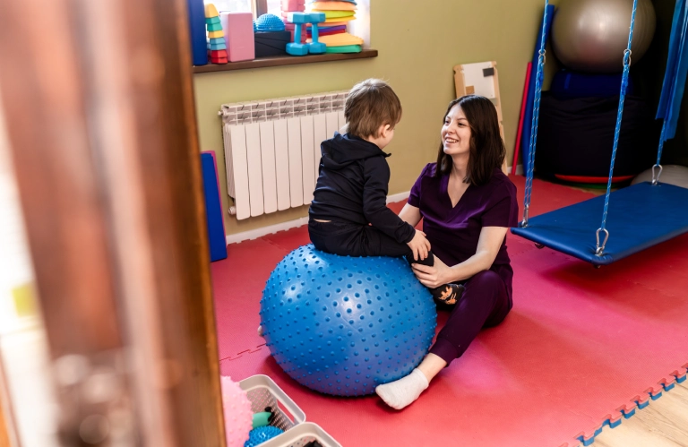 dziecko na niebieskiej piłce